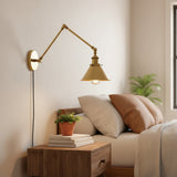 Brass sconce with a cone shade shown at an angle on white