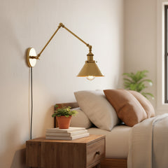 Brass sconce with a cone shade shown at an angle on white