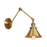Brass sconce with a cone shade lit warm on a white background