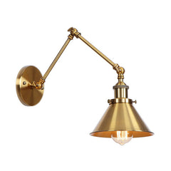 Brass sconce with a cone shade lit warm on a white background