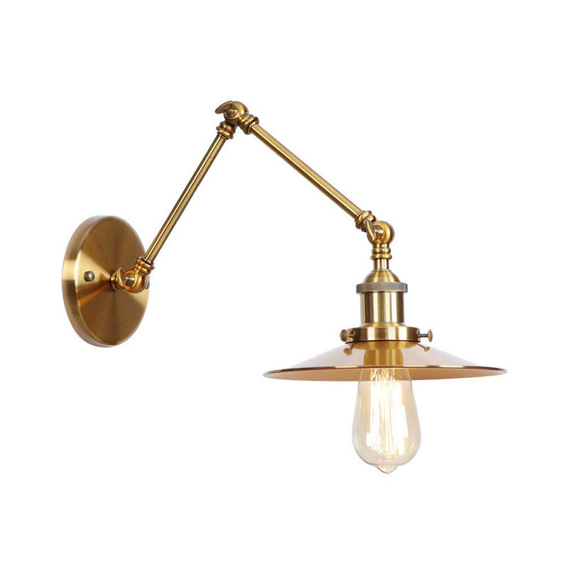 Brass sconce with a flat disc shade and a lit filament bulb