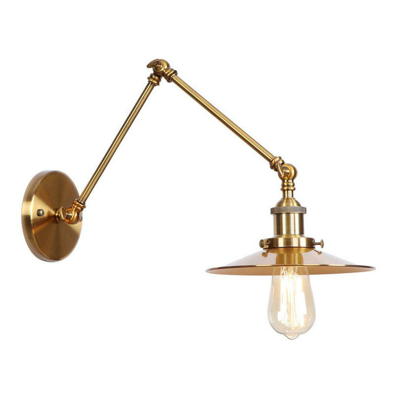 Brass sconce with a flat disc shade lit from below on white