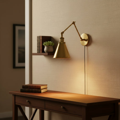 Brass sconce with a deep horn shade angled down on white