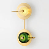 Two light brass sconce with green glass discs stacked on one backplate