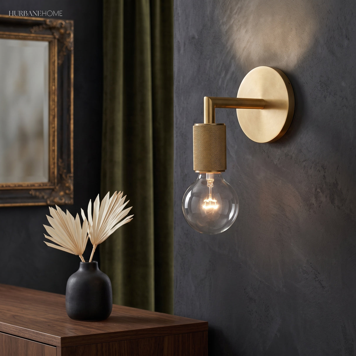 Bare bulb sconce on a dark wall beside a gilt framed mirror