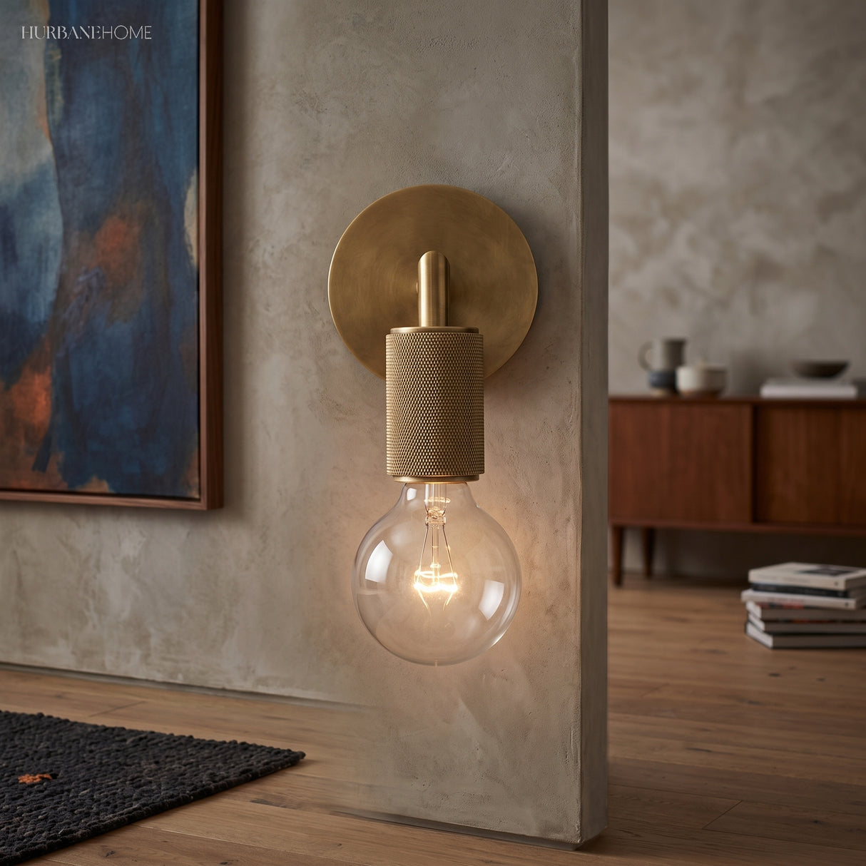 Bare bulb bronze sconce mounted on a pale plaster living room wall