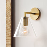 Cone shade sconce on a white wall beside a woven cane panel