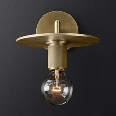 Metal disc shade sconce lit warm against a charcoal background