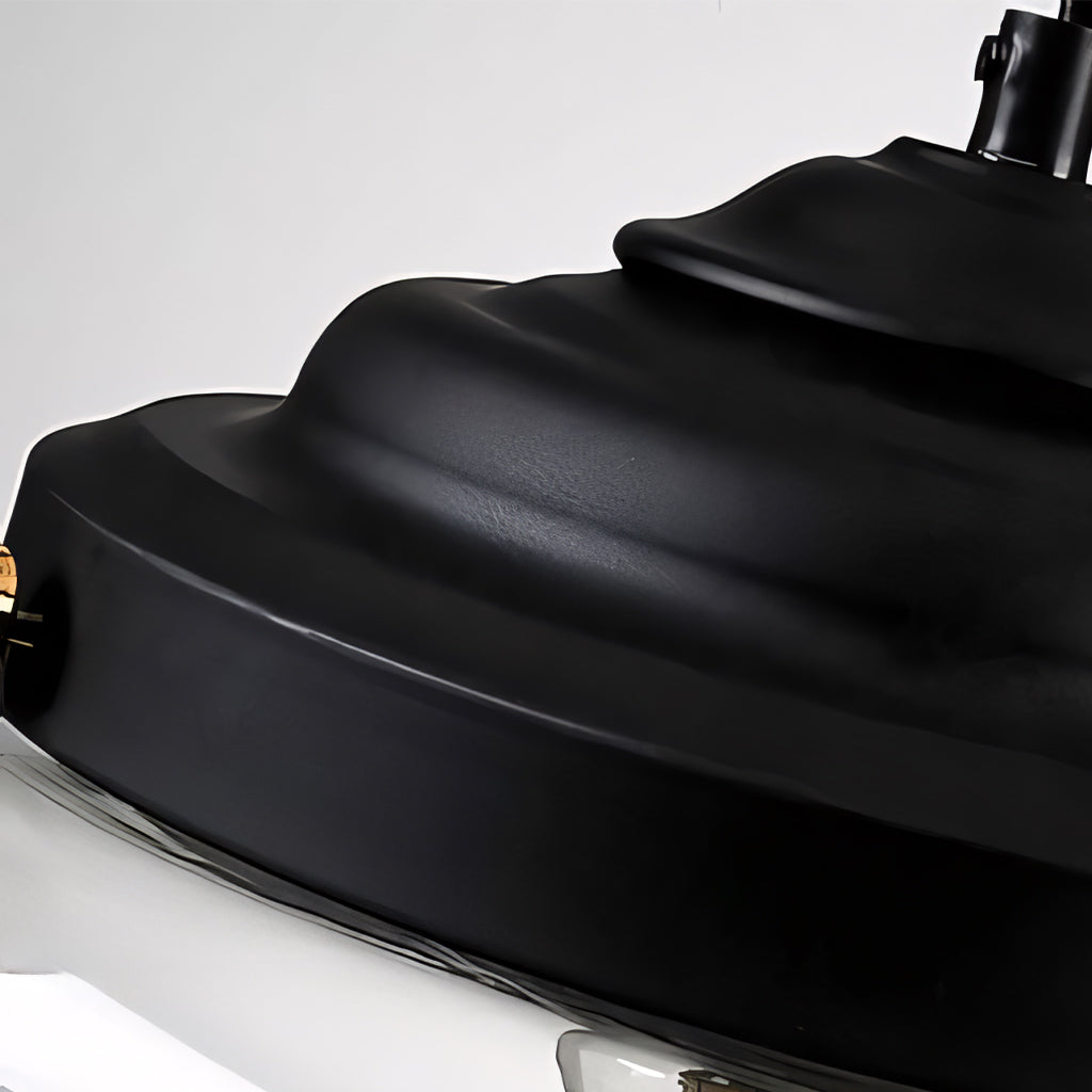 Detailed close-up of the black stepped metal cap crowning the clear glass pendant fixture