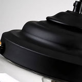 Detailed close-up of the black stepped metal cap crowning the clear glass pendant fixture