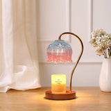 Candle warmer lamp with a pink and blue flower glass shade above a lit candle jar