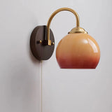 Caramel gradient dome glass sconce with brass arm and wood backplate