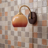 Caramel gradient oval sconce on a mosaic tile wall with plug-in cord