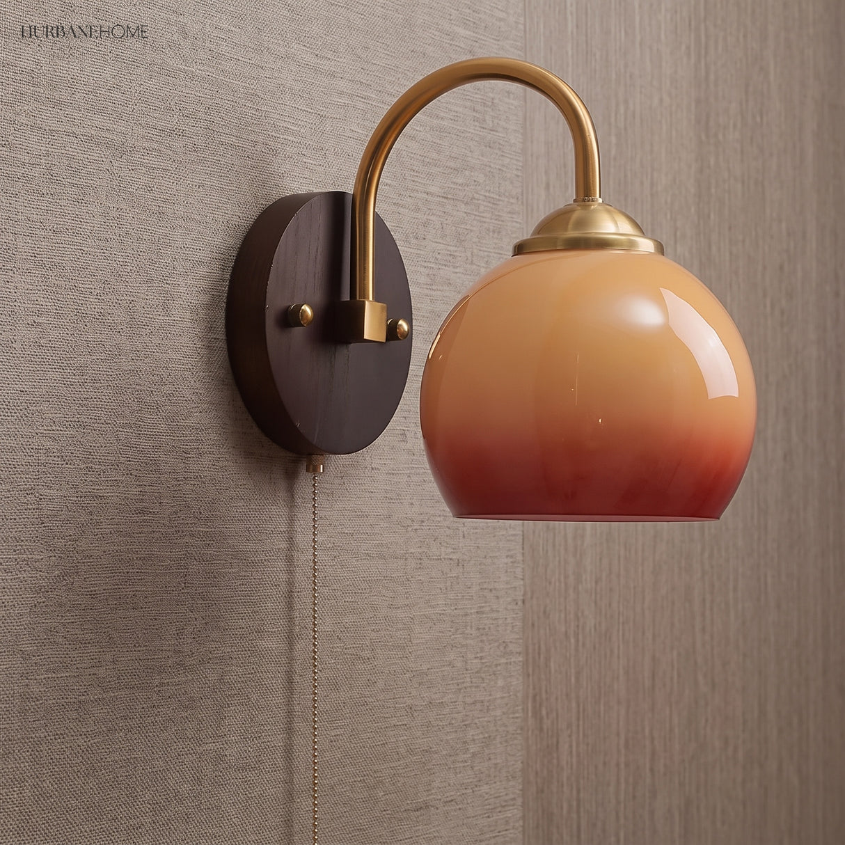 Caramel gradient glass sconce with plug-in cord against a woven wall