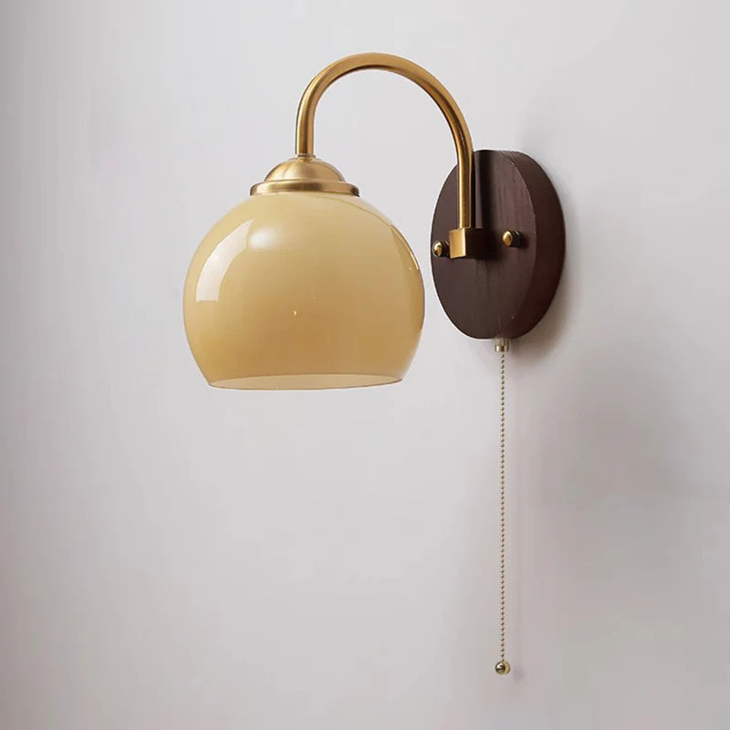 Caramel gradient oval glass sconce with brass arm and pull chain