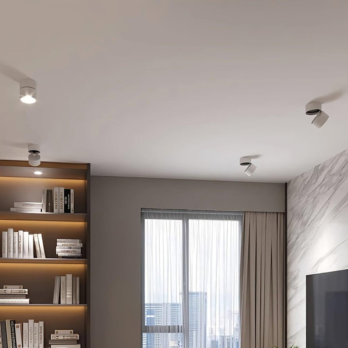 Spot lights lighting a full height bookshelf beside a curtained window