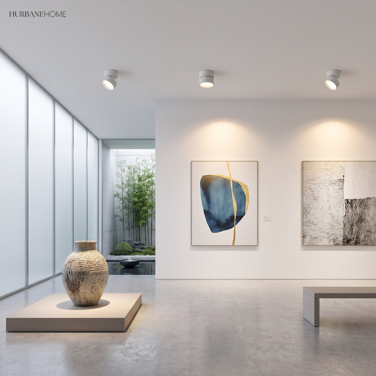 White ceiling spot lights angled at framed artwork in a bright gallery room