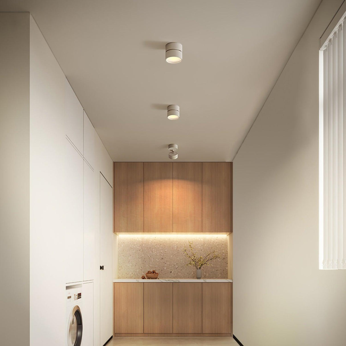 White spot lights running down a hallway ceiling toward a lit utility recess