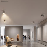 Ceiling spot lights lighting sculptures and hung panels in an open gallery space