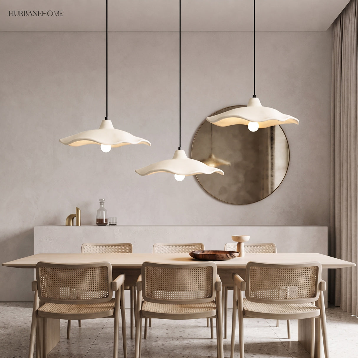Three cement flower pendant lights over a dining table with rattan chairs