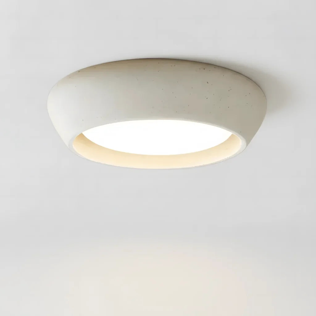 Minimalist cement dome flush mount ceiling light shown from a front three quarter angle