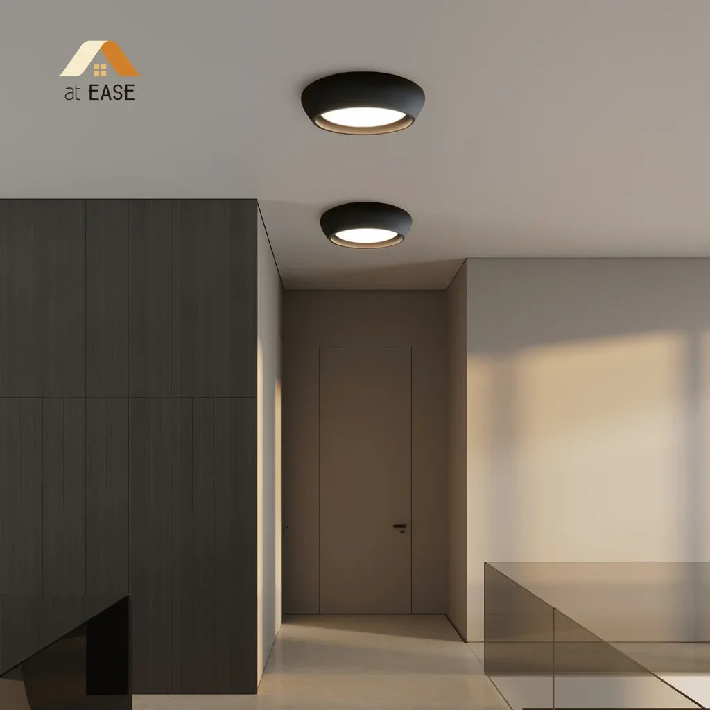 Round cement flush mount ceiling light lit softly in a calm neutral interior