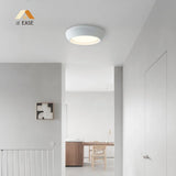 Cement ceiling light mounted flat against a neutral ceiling in a modern room