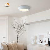 Sculptural cement ceiling light glowing gently against a pale plaster ceiling