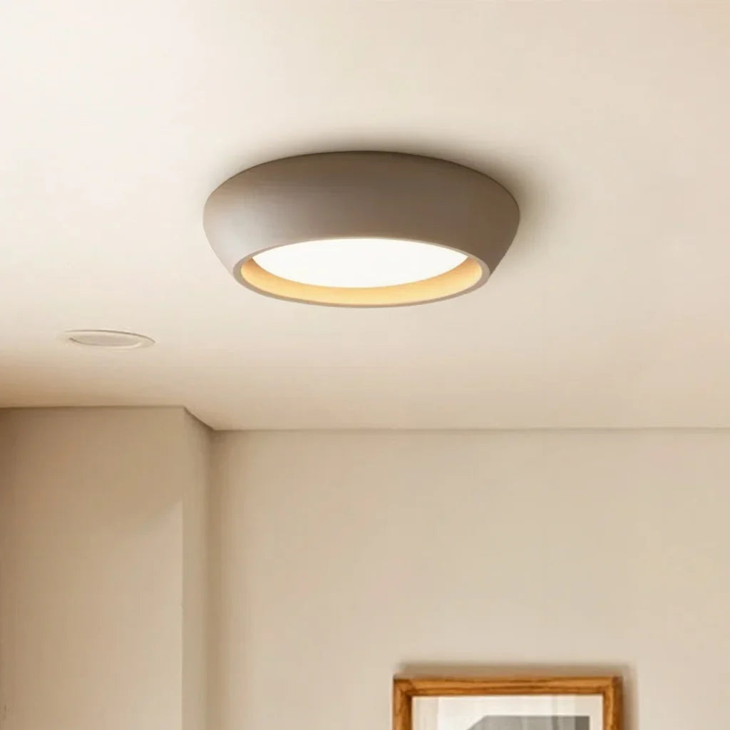Side profile of the low profile round ceiling light against a plain backdrop