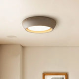 Side profile of the low profile round ceiling light against a plain backdrop