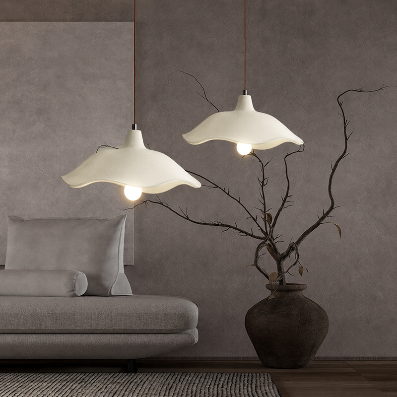 Three-light linear cement pendant fixture over a dining table by a window