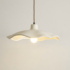 Underside of the off-white cement petal shade around an exposed bulb