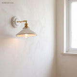 Ceramic and brass wall sconce in a styled interior