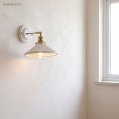 Ceramic and brass wall sconce in a styled interior