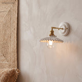 Ceramic and brass wall sconce in a styled interior