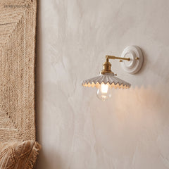 Ceramic and brass wall sconce in a styled interior