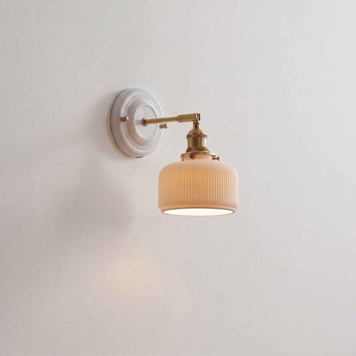 Ceramic shade and brass arm wall sconce, product photo