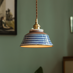 Indigo striped ceramic pendant lit above a framed print