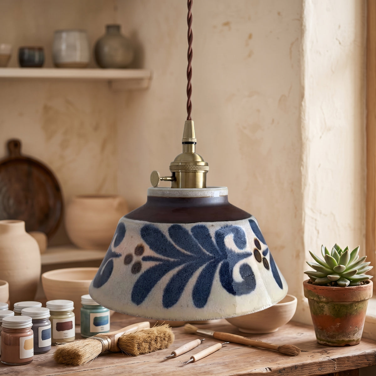 Hand painted blue floral ceramic pendant above a pottery bench