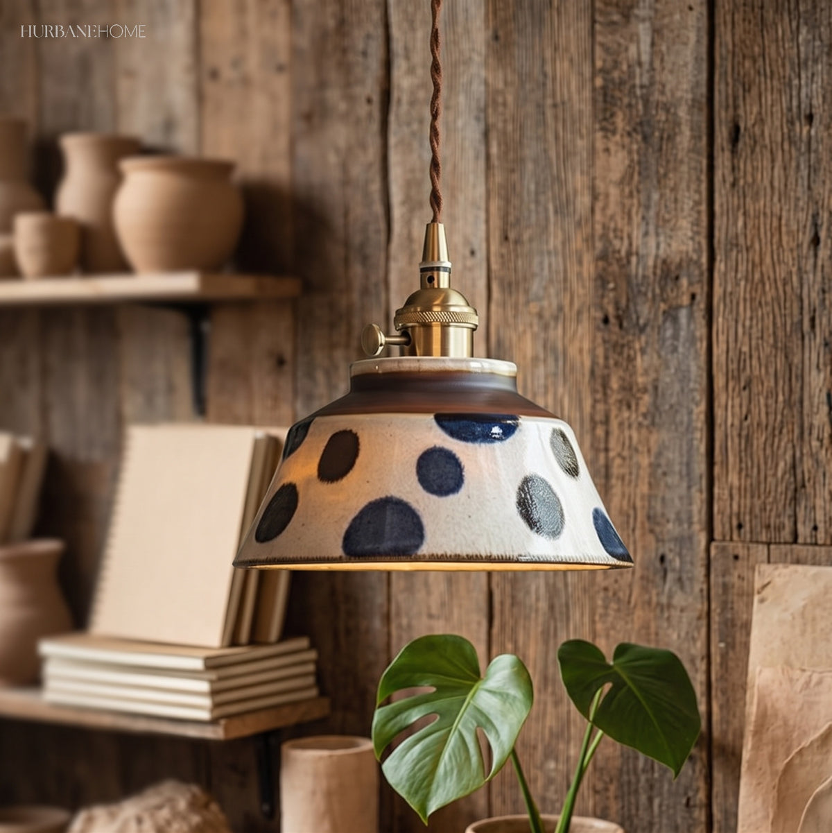 Blue spotted ceramic pendant hanging beside a rustic timber wall
