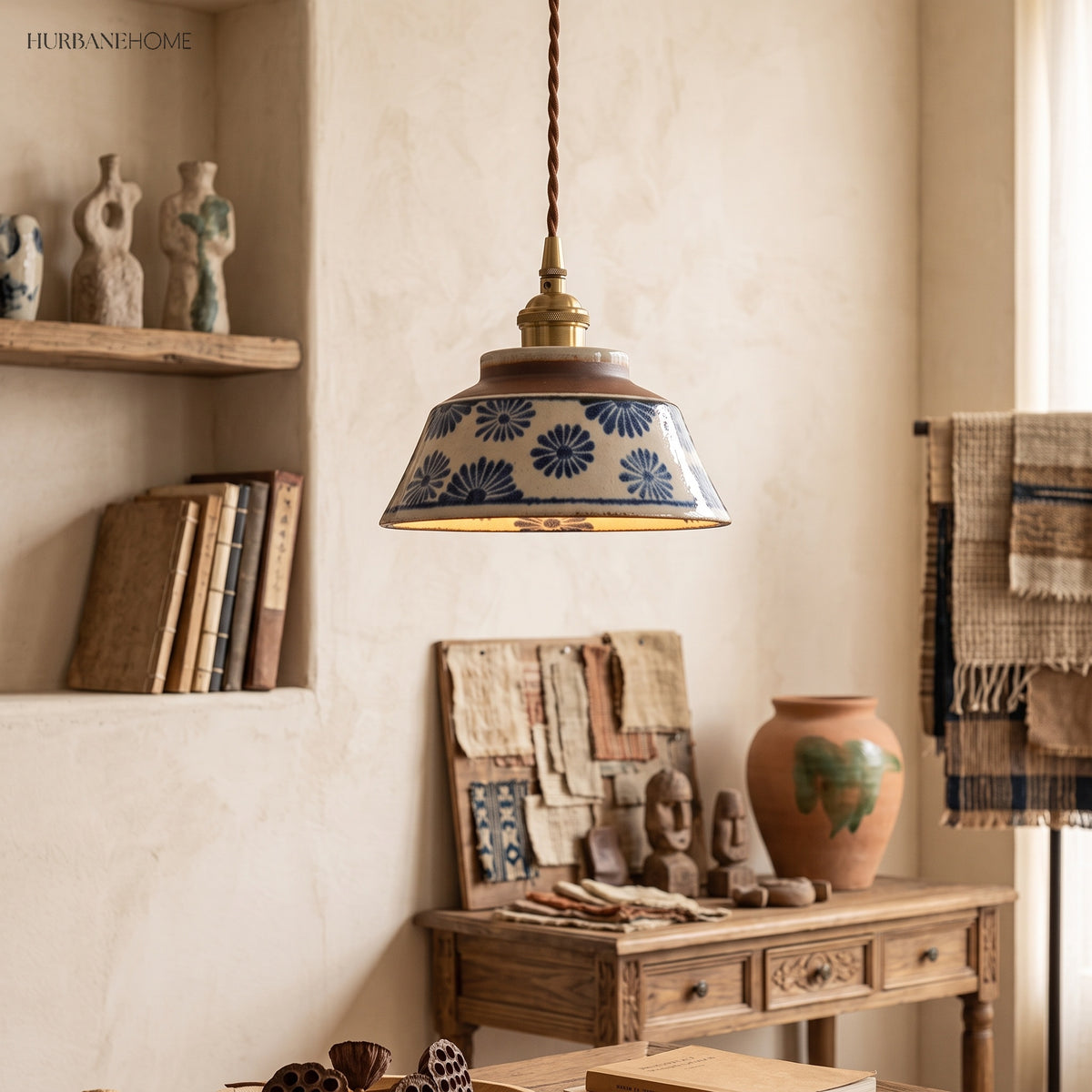 Blue daisy ceramic pendant lit above a workshop table