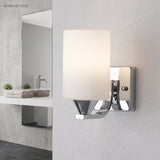 Single chrome vanity light above a bathroom basin with a framed mirror