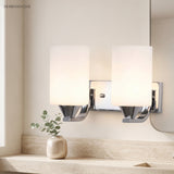 Two light chrome vanity fixture above a travertine bathroom counter and vase