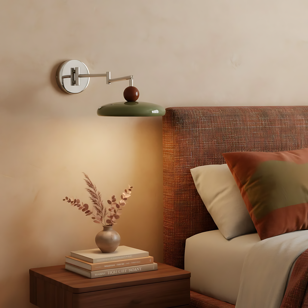 Chrome swing arm sconce with beige shade mounted on a light wall