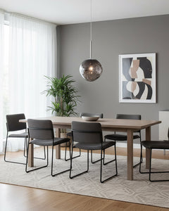 Chrome molten pendant hanging over a grey dining room table and six chairs