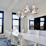 Chrome molten pendants hung above a white office bench with task chairs