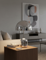 Chrome dome lamp on a square side table in a pale minimal living room