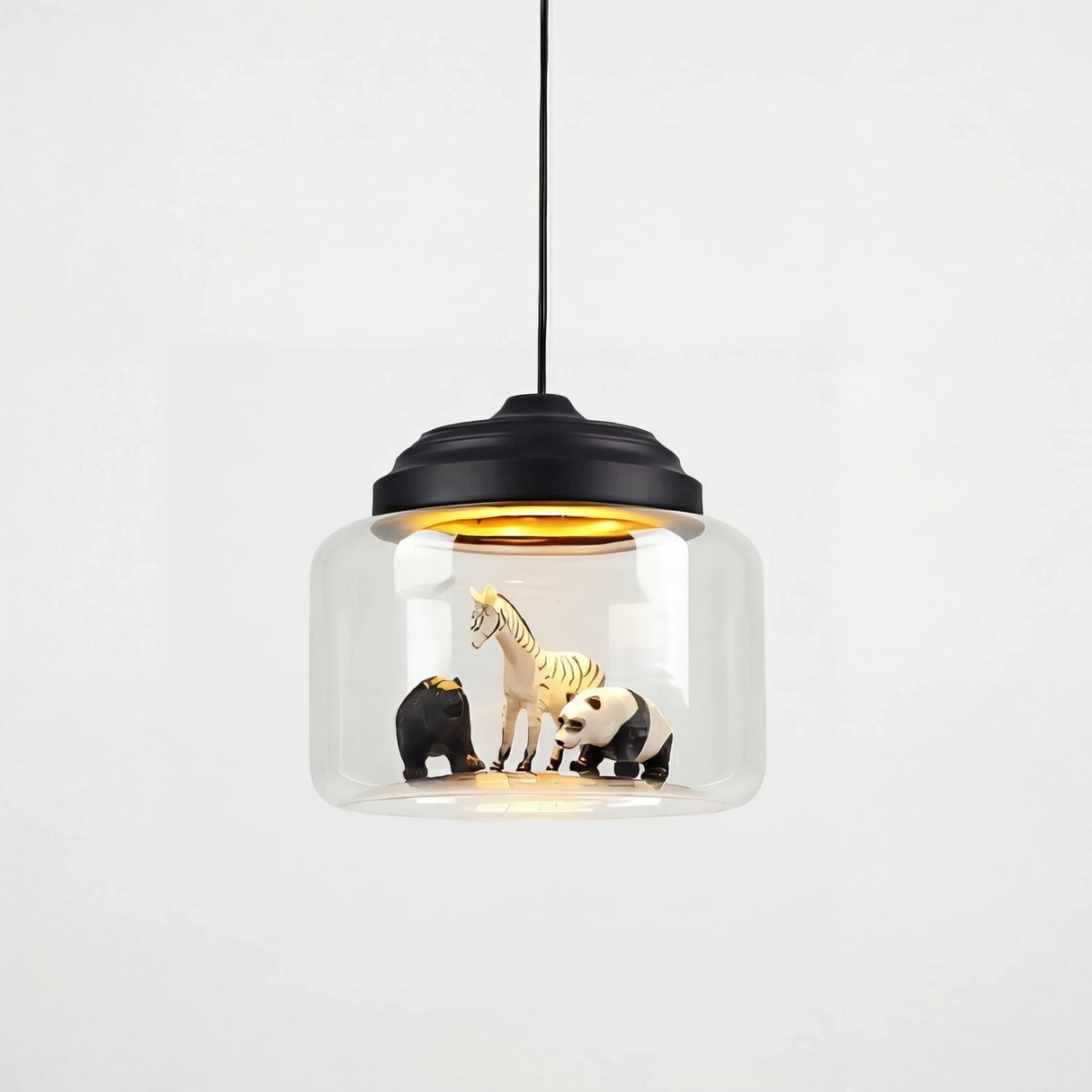 Clear glass drum pendant with black stepped cap holding zebra, bear and panda figures inside