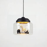 Clear glass drum pendant with black stepped cap holding zebra, bear and panda figures inside