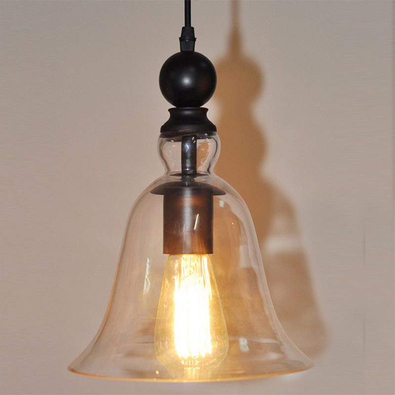 Close view of the lit filament bulb inside the clear bell shade